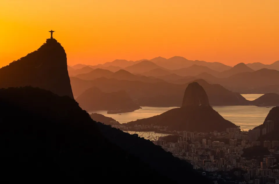 Orange sunrise silhouettes of Corcovado, Sugarloaf and Guanabara Bay in Rio de Janeiro