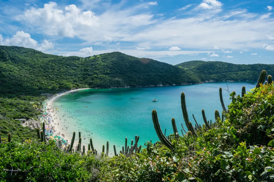 Turquoise bay of Praia do Forno in Arraial do Cabo framed by cacti and green hills