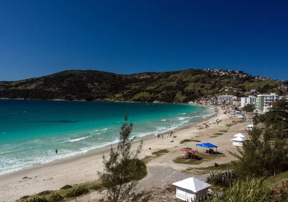White sand beach and turquoise surf at Prainha in Arraial do Cabo under blue sky