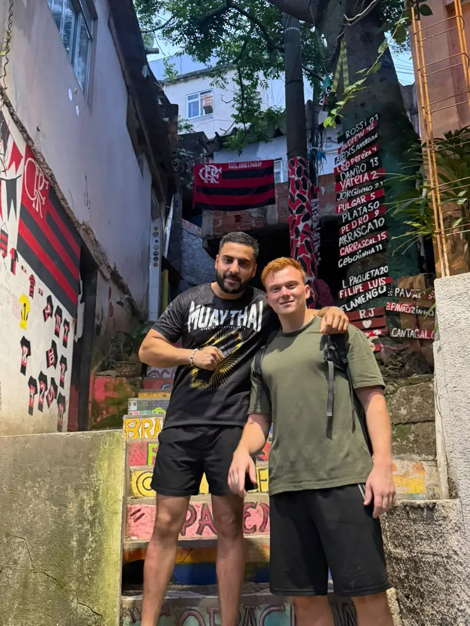Two travellers in a painted alley of a Rio favela