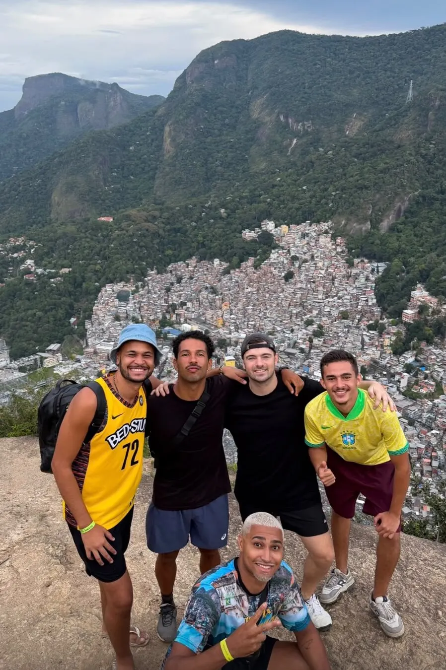 Martin Garrix and friends on top of Dois Irmãos with Rocinha and Pedra da Gávea behind them