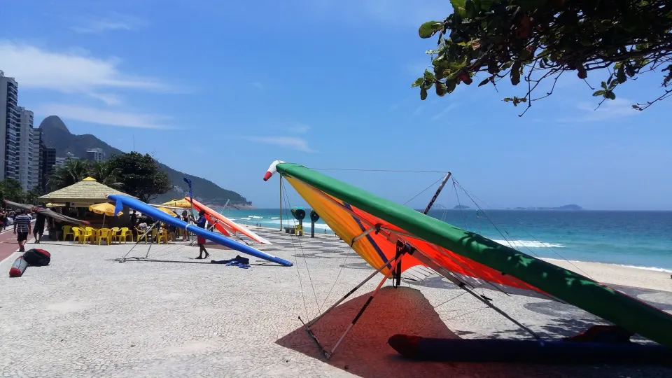 Colorful hang gliders parked on the São Conrado beachfront promenade beside the sea