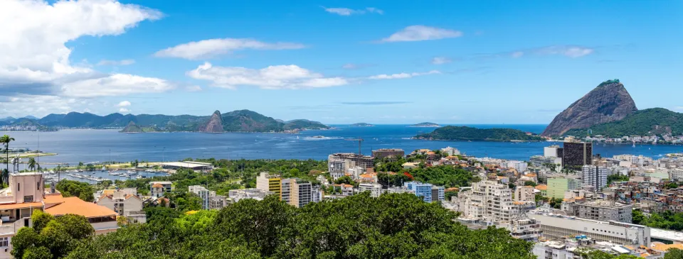 Panoramic view over Rio de Janeiro rooftops toward Guanabara Bay and Sugarloaf Mountain