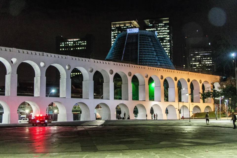Illuminated Lapa Arches at night with the Metropolitan Cathedral and office towers behind