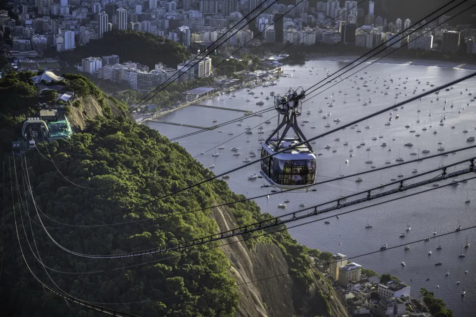 Sugarloaf cable car above Urca hillside with sailboats moored in Botafogo Bay